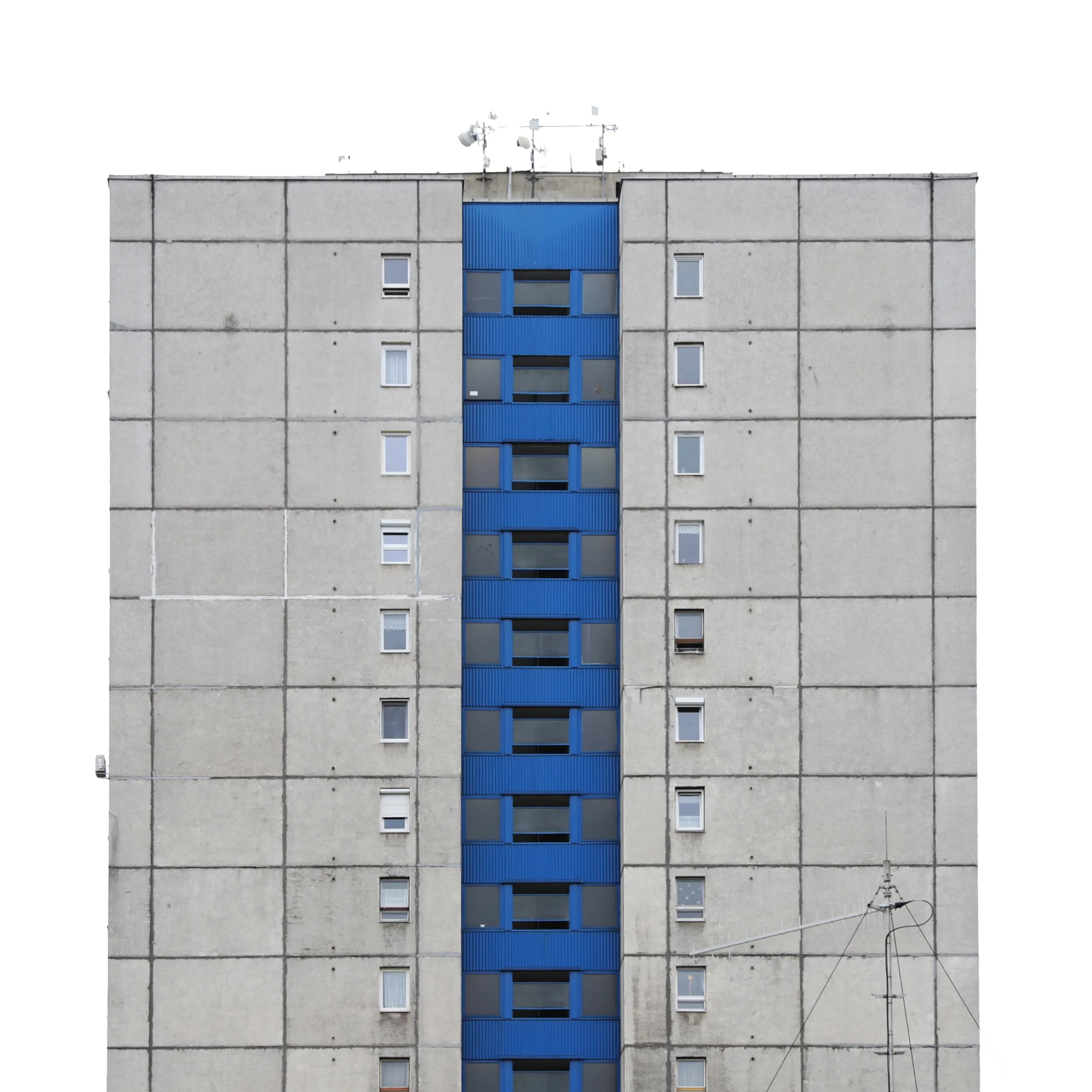 A grey concrete tower block split down the middle by a single column of blue balconies